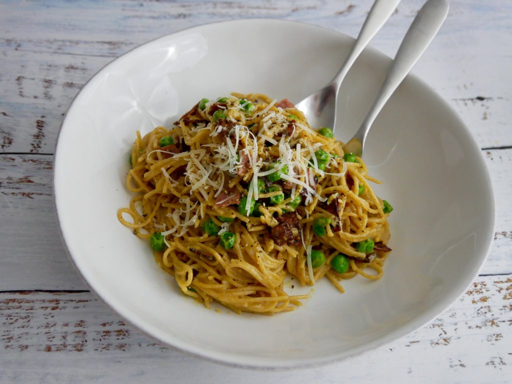 Bowl of spaghetti carbonara with utensils